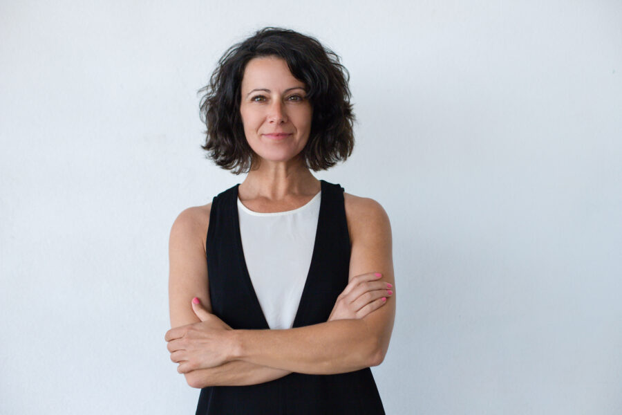 Mulher confiante de braços cruzados, representando o empoderamento feminino na odontologia, destacando a importância das mulheres na profissão.