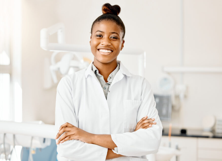 Imagem de uma mulher sorridente em um consultório odontológico, representando a presença de mulheres na odontologia.